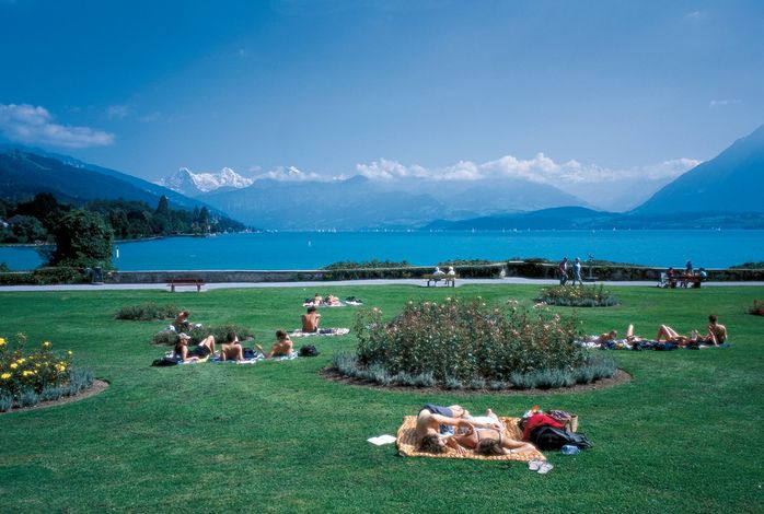 Город Тун, кантон  Бернес Оберланд, находится на берегах одноименного озера. В хорошую погоду жители города и туристы выбираются в парк, расположенный у воды, и принимают солнечные ванны. На заднем плане видны три самые высокие горы кантона - Эйгер, Мёнх и  Юнгфрау.