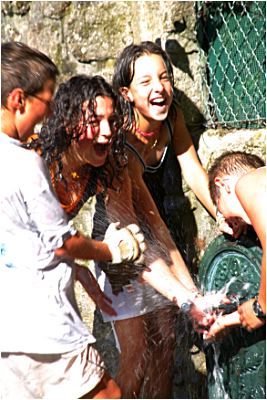 дети играют с водой у фонтана